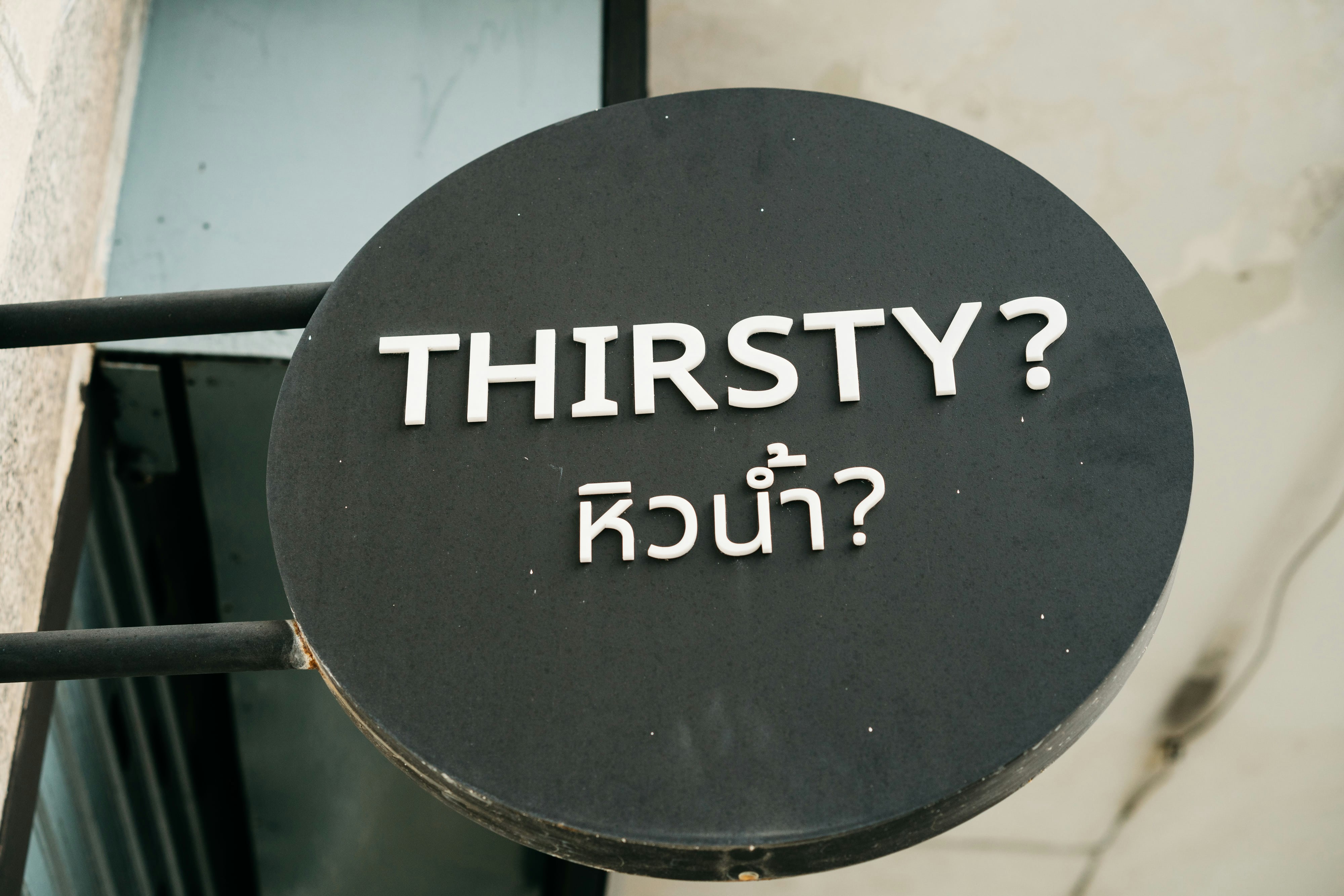 a sign that says thirsty on the side of a building